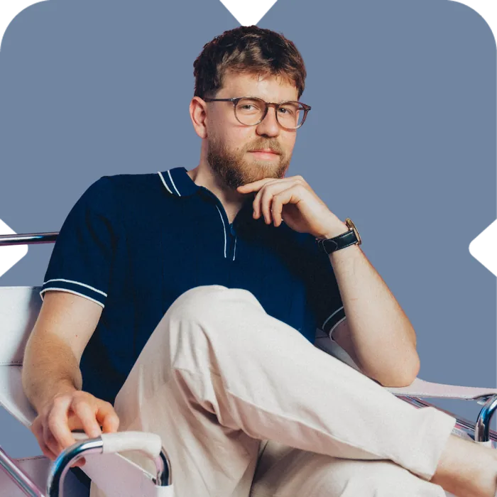 Dominik, CTO i Head of Technology w LIVEPLAN, siedzi w fotelu i uśmiecha się do kamery